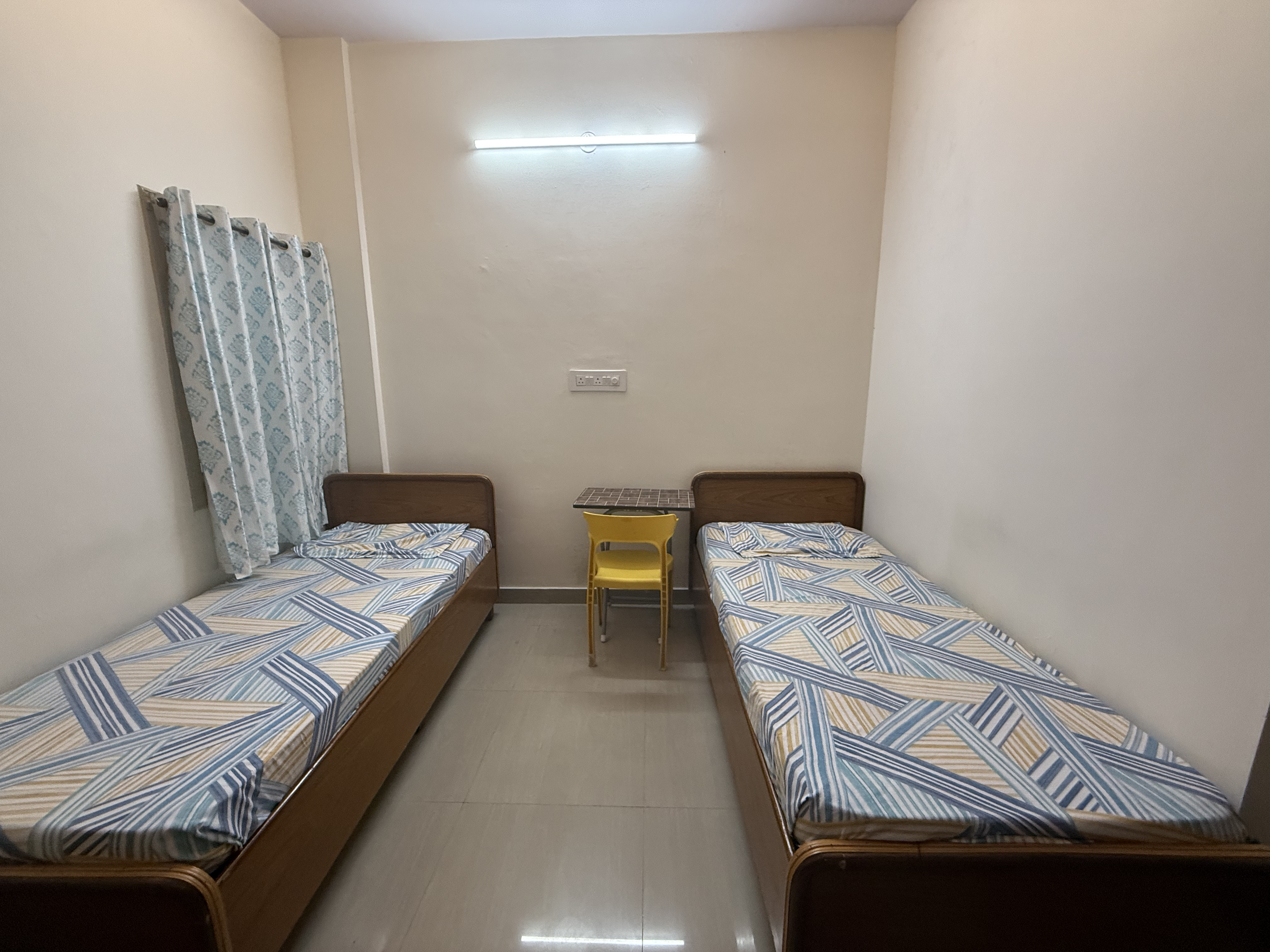Premium student room with attached bathroom at Pelagia Palace PG near Christ University